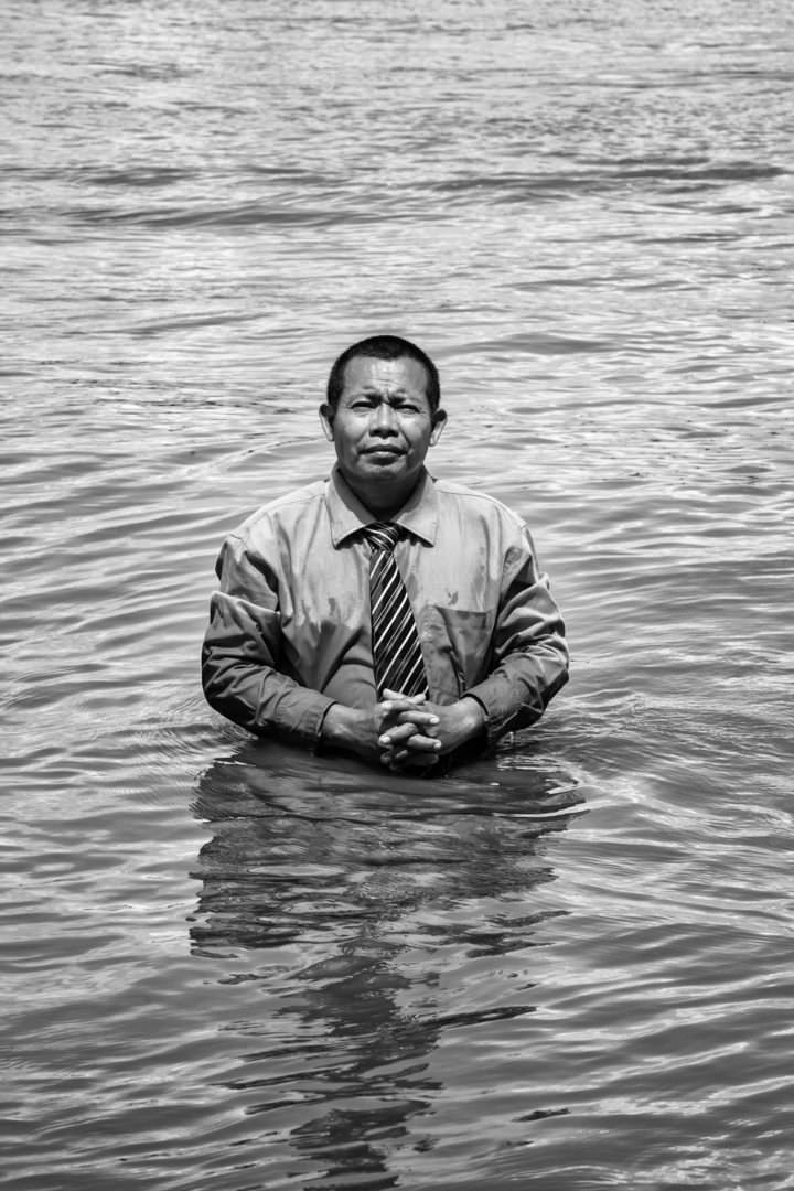 retrato de pastor indígena a orillas del río esperando para bautizar a un discípulo